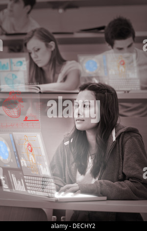 Hübsche Studentin auf ihrem futuristischen Laptop arbeiten konzentriert Stockfoto