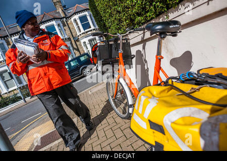 London, UK. 16. September 2013. Die Royal Mail-Flotation droht ebenso wie TNT Studien eine eigene Tür zu Tür service im Süden von London. Dies hat dazu geführt, das Erscheinungsbild der Briefträger mit markanten orangefarbenen Fahrräder der Marke TNT. Diese sind geworden ein Kuriosum und eine Bedrohung für die traditionelle Briefträger, die sind "verwirrt", dass sie unbeaufsichtigt, entriegelt und offen für Diebstahl auf Wohnstraßen, während immer noch anscheinend voll gelassen werden der Post. Bildnachweis: Guy Bell/Alamy Live-Nachrichten Stockfoto
