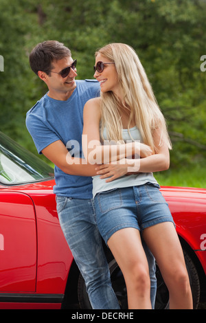 Lächeln, paar umarmt und gelehnt cabriolet Stockfoto