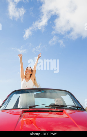 Fröhliche Frau im Cabriolet während ihr Freund fahren Stockfoto