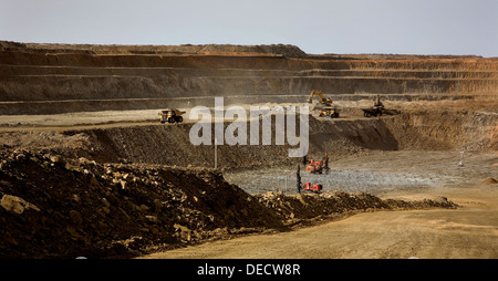 Oberfläche gold Grube Bergbau, Bohren von Löchern für Gebühren vor der Explosion mit Bagger und LKW auf Bank hinter, Mauretanien Stockfoto