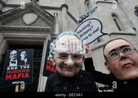 Demonstranten mit Masken von James Murdoch (L) und sein Vater Rupert (R) zeigen außerhalb der Leveson-Anfrage Stockfoto