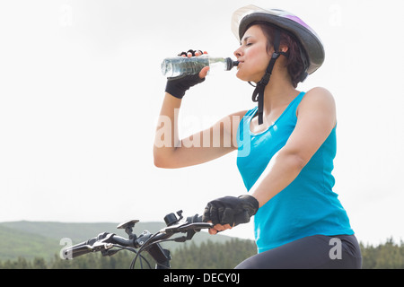 Sportliche Frau auf Mountain-Bike-Trinkwasser Stockfoto