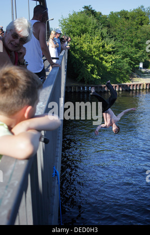 Berlin, Deutschland, springt ein junger Mann von der Fußgängerbrücke in der Spree Stockfoto