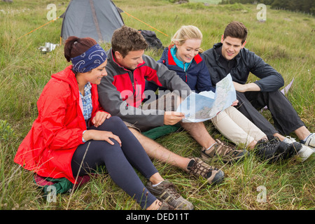 Freunde sitzen Blick auf Karte auf camping-Ausflug Stockfoto