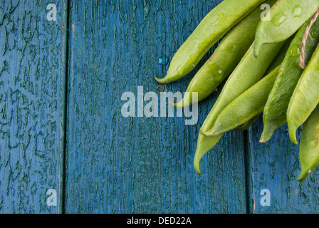 Frische grüne Stangenbohnen auf einem rustikalen hölzernen Hintergrund Stockfoto