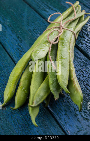 Frische grüne Stangenbohnen auf einem rustikalen hölzernen Hintergrund Stockfoto