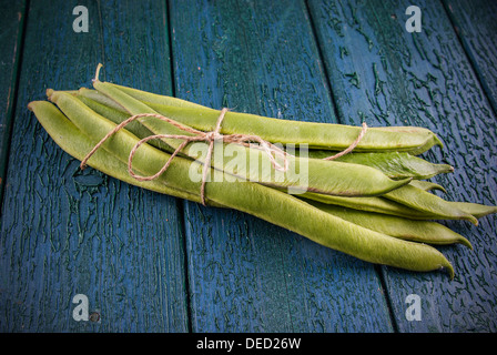 Frische grüne Stangenbohnen auf einem rustikalen hölzernen Hintergrund Stockfoto