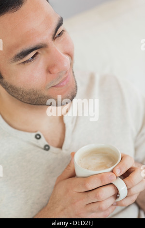 Lächelnde nachdenklicher Mann halten Tasse Kaffee Stockfoto