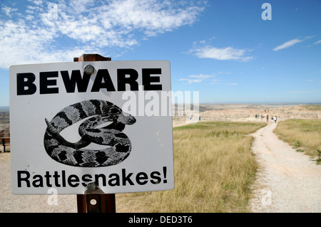 Warnzeichen für Spaziergänger auf einem Pfad zu einem Aussichtspunkt in Badlands Nationalpark, South Dakota. Stockfoto