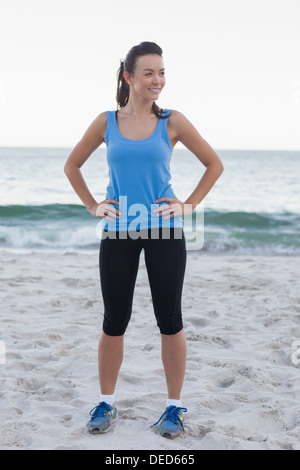 Brünette Frau trägt Sportkleidung vor Ozean Stockfoto
