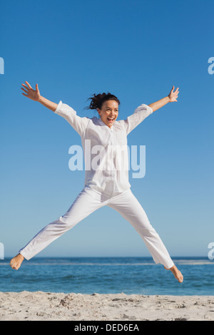Happy woman jumping on the beach Stockfoto