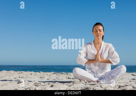 Friedliche Frau praktizieren Yoga am Strand Stockfoto