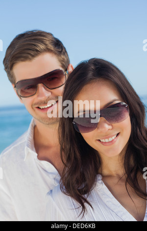 Junges Paar, das Tragen von Sonnenbrillen und lächelnd Stockfoto