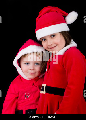 Ein kleiner Junge und ein Mädchen gekleidet in Weihnachtsmann Kostüme für Weihnachten. Stockfoto