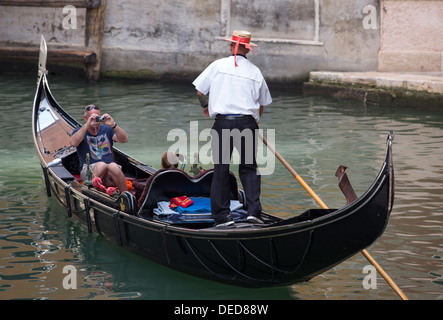 Gondoliere nimmt Touristen ON A CANAL. VENEDIG, ITALIEN Stockfoto