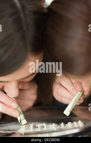 Zwei Mädchen, die eine illegale weiße Substanz Schnauben Stockfoto