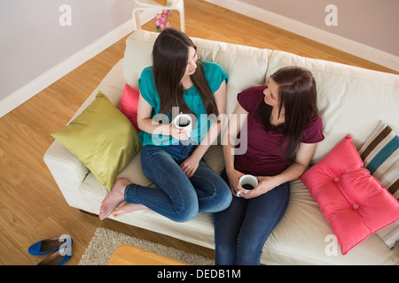 Zwei glückliche Freunde Kaffee trinken und plaudern auf der couch Stockfoto