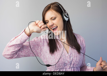Lächelnde junge Brünette Musikhören Stockfoto