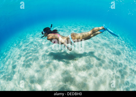 Unterwasserbilder einer Frau über sandigen Boden im tropischen Meer Schnorcheln Stockfoto