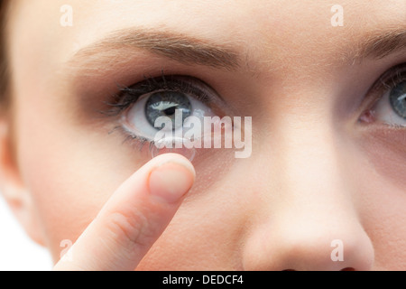Extreme Nahaufnahme auf wunderschöne Modell Anwendung von Kontaktlinsen Stockfoto