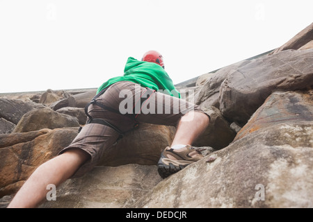 Bestimmt Man aufsteigend eine große Felswand und zu sehen, oben Stockfoto