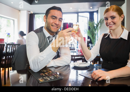 Glücklich Geschäftspartner Klirren Wein Gläser lächelnd in die Kamera Stockfoto