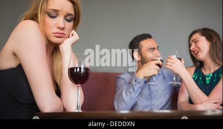 Blonde Frau Gefühl zweier Menschen neidisch sind neben ihr flirten Stockfoto