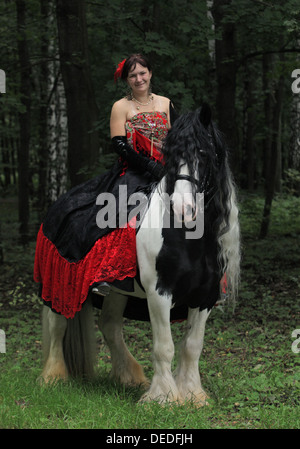 Schöne Zigeunerin mit Pferd im Wald Stockfoto