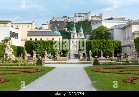 Sommer Stadt Gärten von Schloss Mirabell mit Blumenbeeten, Brunnen und Statuen und die Festung Hohensalzburg hinter Salzburg Stockfoto
