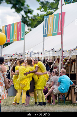 Eine Theatergruppe verkleidet als Küken einen Besucher das Wildnis-Festival in Cornbury Park Oxfordshire, UK umarmen Stockfoto