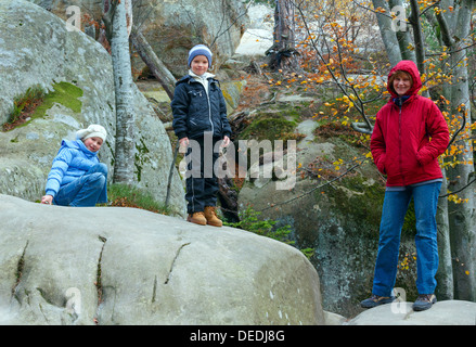 Familie im herbstlichen Wald mit großen hohen Steinen ("Skeli Dovbusha", Frankowsk Region, Ukraine) Stockfoto