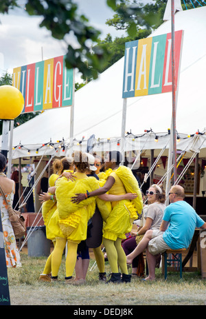 Eine Theatergruppe verkleidet als Küken einen Besucher das Wildnis-Festival in Cornbury Park Oxfordshire, UK umarmen Stockfoto