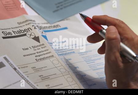 Abbildung - eine illustrierte Bild zeigt eine Hand mit einem Stift über Stimmzettel für die deutschen Parlamentswahlen 2013 in Kaufbeuren, Deutschland, 17. September 2013. Foto: KARL-JOSEF HILDENBRAND Stockfoto