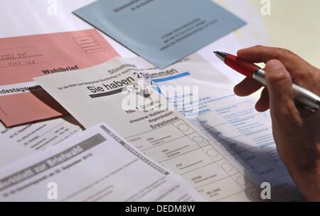 Abbildung - eine illustrierte Bild zeigt eine Hand mit einem Stift über Stimmzettel für die deutschen Parlamentswahlen 2013 in Kaufbeuren, Deutschland, 17. September 2013. Foto: KARL-JOSEF HILDENBRAND Stockfoto