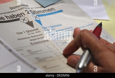 Abbildung - eine illustrierte Bild zeigt eine Hand mit einem Stift über Stimmzettel für die deutschen Parlamentswahlen 2013 in Kaufbeuren, Deutschland, 17. September 2013. Foto: KARL-JOSEF HILDENBRAND Stockfoto