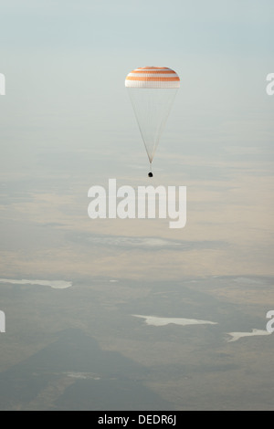 Die Sojus-Sonde TMA-08M mit Expedition 36-Astronauten landet nach einer erfolgreichen Mission an Bord der Internationalen Raumstation in Kasachstan. Das Raumschiff steigt mit einem Fallschirm zum Landeplatz in Zhezkazgan ab. Stockfoto