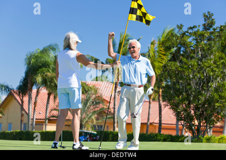 Ältere Mann und Frau Brautpaar zusammen feiern auf ein Putting Green Golf spielen Stockfoto