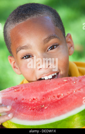 Niedlich, lächelnde & glücklich afroamerikanischen jungen Kind essen ein Stück saftiger Wassermelone Stockfoto