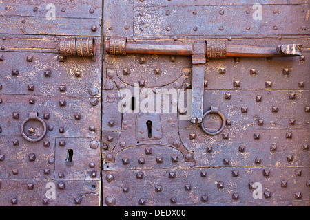 Alt und rostig Metalltür mit vielen Schlüssellöcher und antiken Türverriegelung Stockfoto