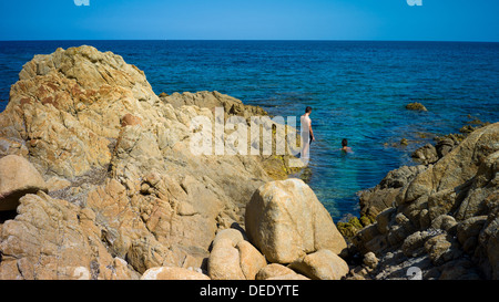 Capo Comino, Italien, Badegäste auf der felsigen Küste Capo Comino in Sardinien Stockfoto