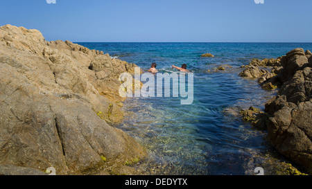 Capo Comino, Italien, Badegäste auf der felsigen Küste Capo Comino in Sardinien Stockfoto