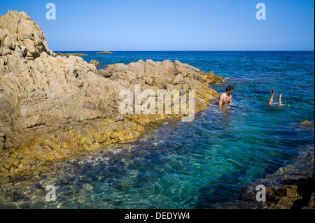 Capo Comino, Italien, Badegäste auf der felsigen Küste Capo Comino in Sardinien Stockfoto