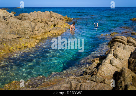 Capo Comino, Italien, Badegäste auf der felsigen Küste Capo Comino in Sardinien Stockfoto