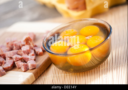 Sechs rohe Eigelb in Glas Schüssel und hacken Wurst Stockfoto