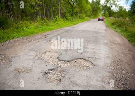 Schlagloch und Trümmern in baufälligen Wälder Straße Stockfoto