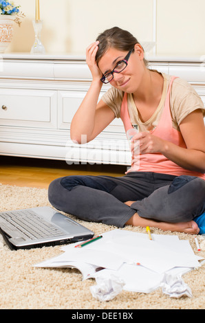 Betonte Schulmädchen studieren in ihrem Zimmer Stockfoto