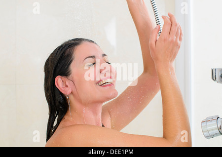 Frau unter der Dusche genießen Wasser spritzt auf Ihr Stockfoto