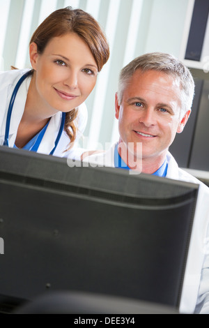 Männliche & weiblichen Ärztinnen und Ärzte in einem Krankenhaus Büro Computer verwenden Stockfoto