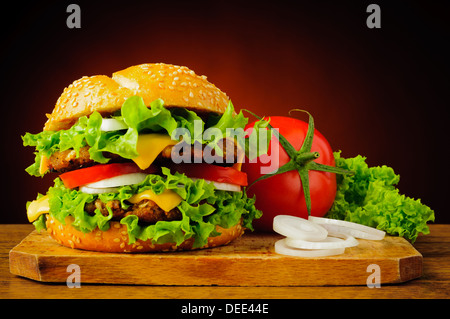 Stillleben mit doppelten Cheeseburger oder Hamburger und frischem Gemüse Stockfoto
